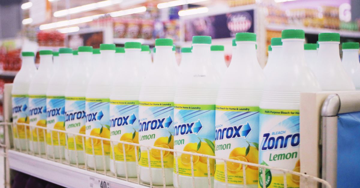 Pasillo de supermercado con góndolas metálicas alineadas y bandejas vacías